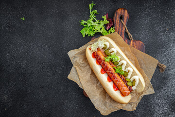 hot dog sandwich bun, sausage, gherkin, ketchup, mayonnaise fast food meal food snack on the table copy space food background rustic top view