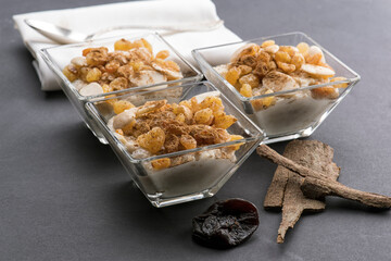 Delicious rice pudding with cinnamon in bowl, topped with almonds nuts and raisins
