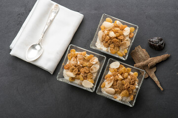 Delicious rice pudding with cinnamon in bowl, topped with almonds nuts and raisins