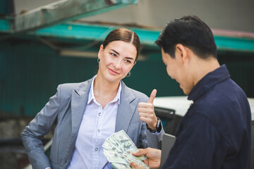 Female manager and car mechanic while working in auto repair shop, Young business woman showing thumbs up, Car repair and maintenance