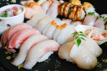 A platter of assorted nigiri sushi (tuna, salmon, kingfish, snapper, scallop, eel, sea urchin,...