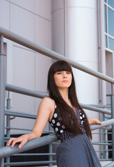 beautiful young brunette woman on the background of a modern building