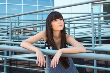 beautiful young brunette woman on the background of a modern building