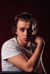 a young man sits leaning back in surprise and challenged on the back of a chair