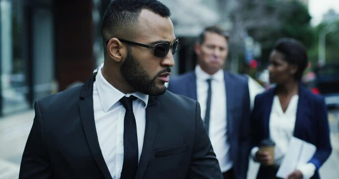 Bodyguard, business team walking in the city streets together with bodyguard black suits. Safety or safe keeping, authority and serious people walk downtown or urban road for protection or defence