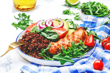 Grilled chicken meat, red quinoa healthy salad  with tomatoes, avocado, arugula and spinach. Detox, ketogenic diet food. White table background, top view