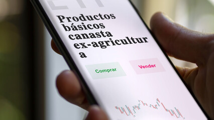 An investor analyzing an etf fund. ETF text in Spanish : commodities basket ex-Agriculture, buy,...