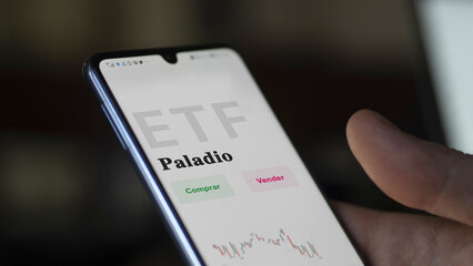 An investor analyzing an etf fund. ETF text in Spanish : palladium, buy, sell.
