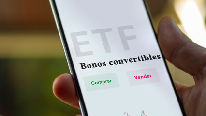 An investor analyzing an etf fund. ETF text in Spanish : convertible bonds, buy, sell.