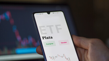 An investor analyzing an etf fund. ETF text in Spanish : silver, buy, sell.