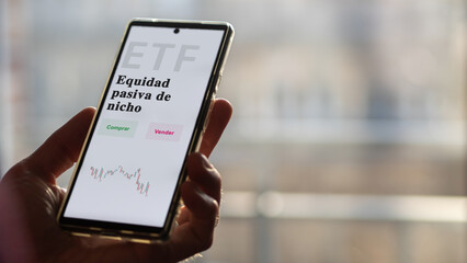 An investor analyzing an etf fund. ETF text in Spanish : niche passive equity, buy, sell.