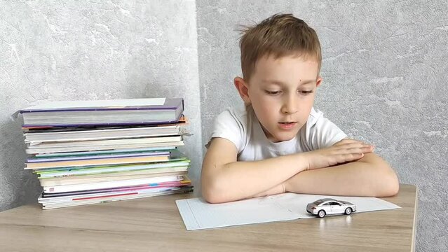 Tired boy with ADHD is bored in class, distracted, does not want to do homework. Therapy for ADHD children.  Attention deficit and hyperactivity in children, neuropsycho