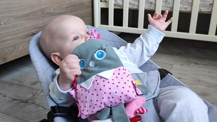 baby girl lies in a children's cocoon and plays with a toy bunny, the concept of motherhood, a disgruntled child
