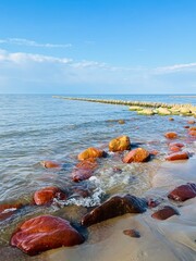 Orange stones at the sea coast, blue sea view
