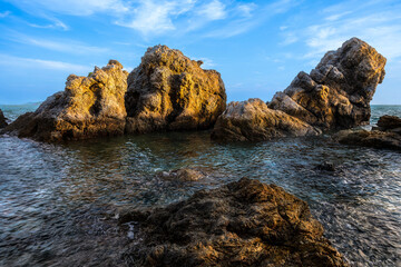 Fototapeta na wymiar Rocks on Nang Rong Beach with blue sky background at Sattahip, Chonburi, Thailand.