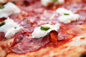 Italian thin crust pizza with prosciutto, jalapeno and buratta cheese