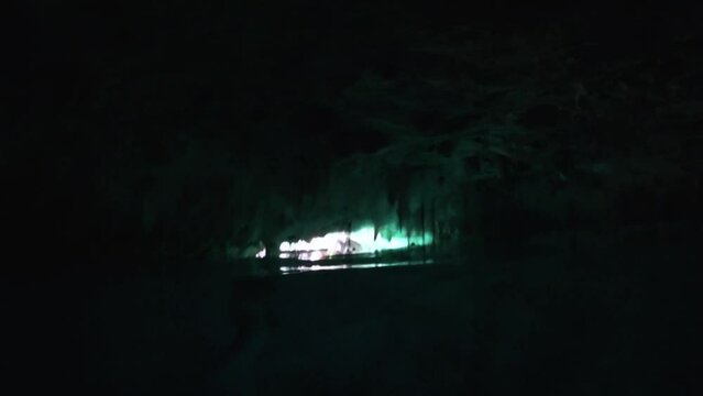 View into dark cave with diving snorkeling person at the 'Gran Cenote' natural limestone pool in Tulum, Mexico