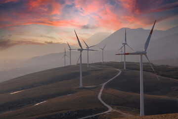 A wind farm or wind park at sunset clouds located in the mountains of Italy Europe and it allows to...