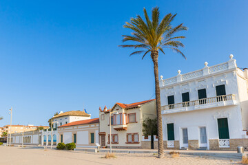 Fototapeta na wymiar Palmtree and houses at the boulevard in Comarruga, Spain