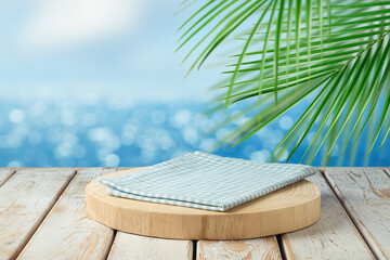 Empty wooden podium with tablecloth on table over tropical beach bokeh background.  Summer mock up...