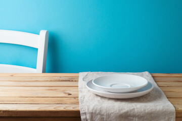 White plates on table with tablecloth over blue  background. Kitchen mock up for design and product display