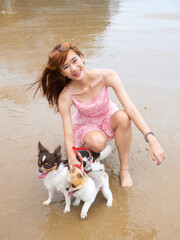 young girl with dogs sitting on the beach. by sea. tropical beach, summer style.