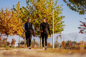 Obraz premium A front view photo of sporty couple hanging out in the park and having a conversation