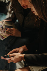 Obraz premium Girl showing something on the phone to her friend. Close up shot