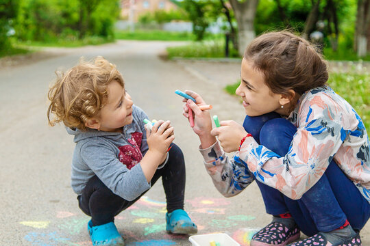 Children draw with chalk on the pavement. Selective focus.