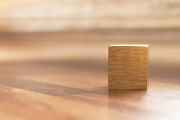 Fototapeta premium Blank wooden cube block on wooden table with shades of light through the window. Copy space for your text or number.