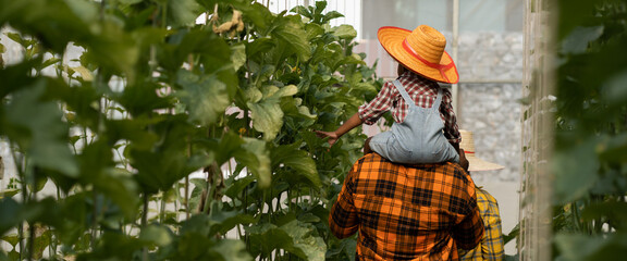 farmer family concept.African man working in greenhouse together with his daughter.black african...