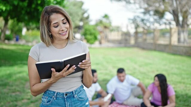 Group of people students reciting book standing at park