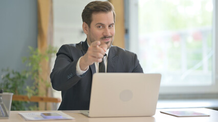 Businessman Clapping for Team while Working on Laptop