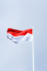 Naklejka na ściany i meble flag of Indonesia, flag of the country, waving flag, red and white flag, waving flag against a clear sky background