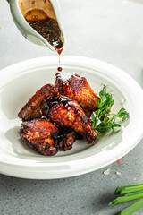 Roasted chicken wings in barbecue sauce with sesame seeds, Food recipe background. Close up
