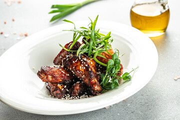 appetizing grilled chicken wings in barbecue sauce with sesame seeds