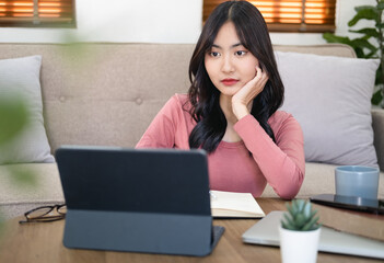 Head shot focused woman taking notes watching webinar, studying online at home, Young female listening to lecture, engaged in internet educational course, remote education , working online.