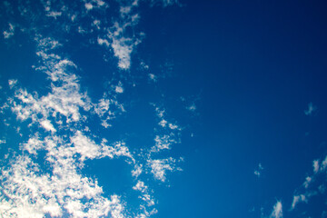 White clouds on clear blue sky rushing by
