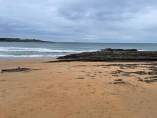 Wonderful beach in Santander Spain. Rocks stick out of the sea. Beautiful sand in the foreground 