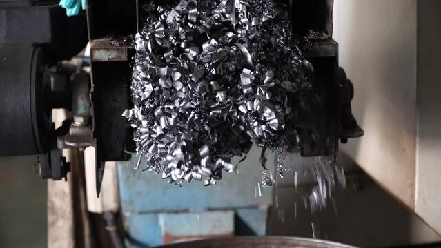 Steel Scrap Moving Scrap Conveyor Lathe Machine,Steel scrap materials recycling. Aluminum chip waste after machining metal parts on a cnc lathe. Closeup twisted spiral steel shavings. Small roughness 