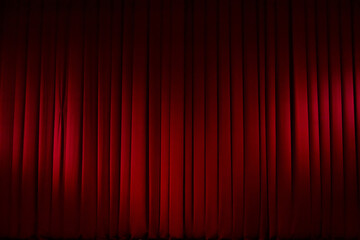 Theatrical stage curtain red in the light of spotlights.