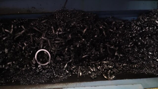 Steel Scrap Moving Scrap Conveyor Lathe Machine,Steel scrap materials recycling. Aluminum chip waste after machining metal parts on a cnc lathe. Closeup twisted spiral steel shavings. Small roughness 