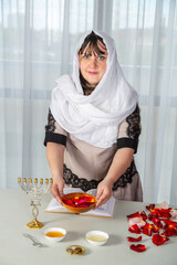 A Jewish woman in a white headscarf performs superstitious conspiracies before the wedding with...