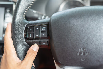 A car driver is pressing the call button on the multifunction steering wheel to receive a call....