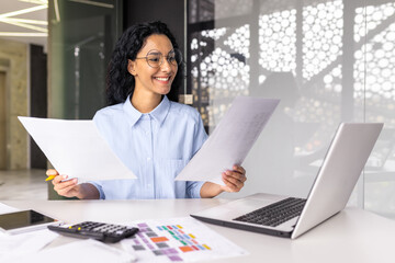 latin american businesswoman working inside office with documents and laptop, worker paperwork...