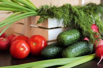 Set of different fresh vegetables close-up. Wooden white basket with harvest. Cucumbers, tomatoes, radishes, green onions and dill