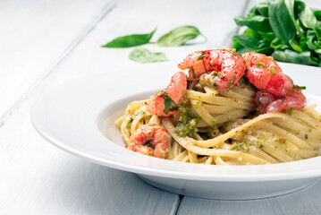 Piatto di deliziose linguine condite con pesto alla genovese e gamberi, cibo italiano 