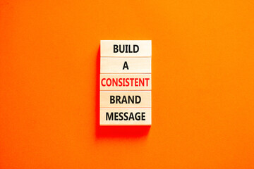 Consistent brand message symbol. Concept words build a consistent brand message on wooden blocks. Beautiful orange table orange background. Business consistent brand message concept. Copy space.