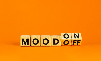 Mood on or off symbol. Businessman turns wooden cubes and changes word Mood off to Mood on. Beautiful orange table orange background. Business and mood on or off concept. Copy space.