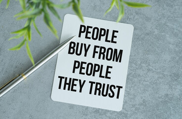 People Buy From People They Trust. Text on tablet device on a gray table